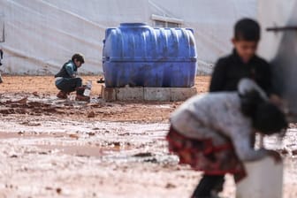 Kinder füllen in einem provisorischen Lager in der Region Idlib Behälter mit Wasser auf.