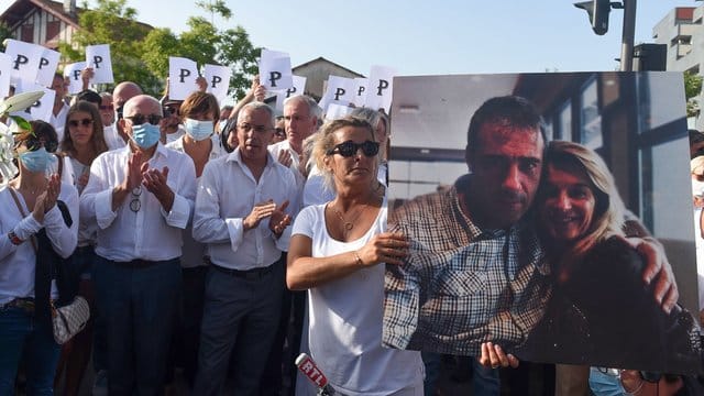 Die Ehefrau des verstorbenen Busfahrers hält während eines Protestmarsches in Bayonne ein Foto von sich und ihrem Mann. Die Ehefrau des verstorbenen Busfahrers hält während eines Protestmarsches in Bayonne ein Foto von sich und ihrem Mann.