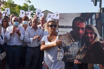Die Ehefrau des verstorbenen Busfahrers hält während eines Protestmarsches in Bayonne ein Foto von sich und ihrem Mann.