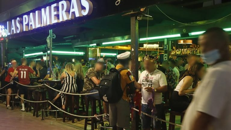 Touristen halten sich in der Bar "Las Palmeras" in der Bierstraße in el Arenal in Palma de Mallorca auf.