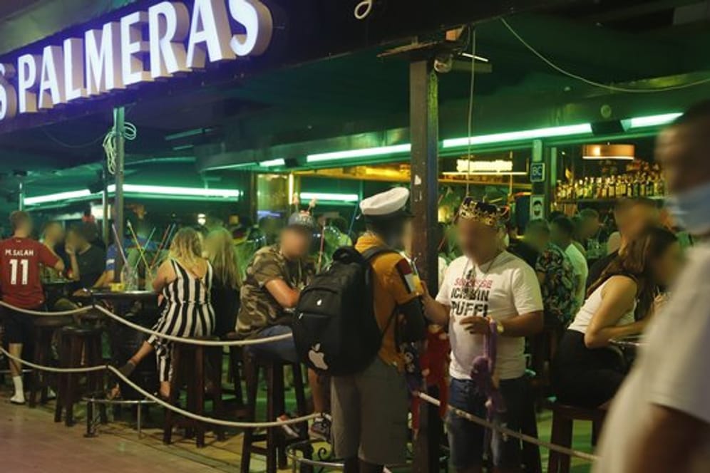 Touristen halten sich in der Bar "Las Palmeras" in der Bierstraße in el Arenal in Palma de Mallorca auf.