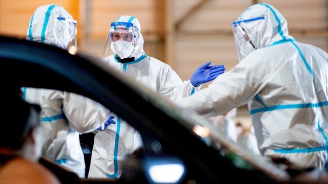 Angehörige der Bundeswehr nehmen in einem stillgelegtem Hubschrauber Hangar in Gütersloh Corona-Abstriche bei der Bevölkerung durch.