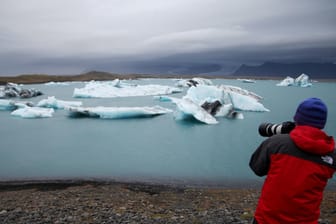 Ein Mann macht an der südisländischen Gletscherlagune Jökulsárlón Fotos vom See und den darin schwimmenden Eisbergen: Der Tourismus auf der Insel ist fast vollkommen zum Erliegen gekommen.