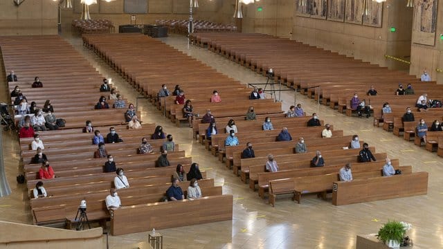 Gläubige sitzen mit Abstand voneinander in einer Kirche in Los Angeles. Gläubige sitzen mit Abstand voneinander in einer Kirche in Los Angeles.