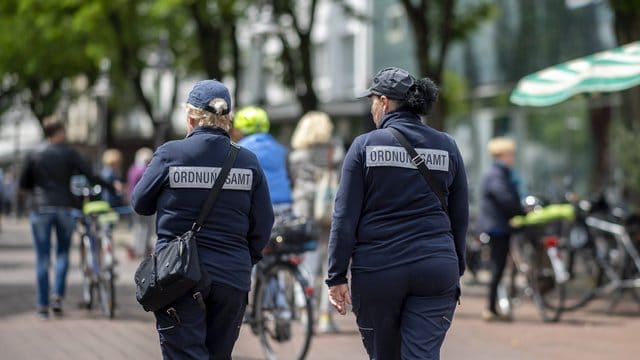 Zwei Mitarbeiterinnen vom Ordnungsamt kontrollieren die Marktstände in der Berliner Straße in der Innenstadt von Gütersloh.
