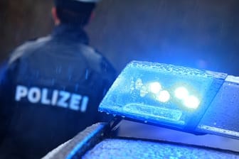 Ein Polizist steht vor einem Streifenwagen: Gegen Münchner Beamte erhebt ein mutmaßlicher Täter nun Vorwürfe.