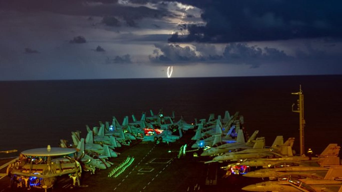 Eskaliert der Streit zwischen den USA und China? Militärjets stehen auf dem Flugdeck des Flugzeugträgers USS Nimitz im Südchinesischen Meer während eines Gewitters.