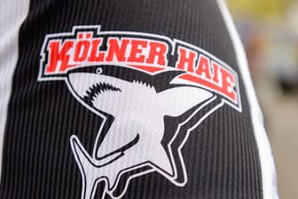 Das Logo der Kölner Haie, auf einem Trikot aufgedruckt: Ein Profi des Clubs hat sich mit dem Coronavirus infiziert.