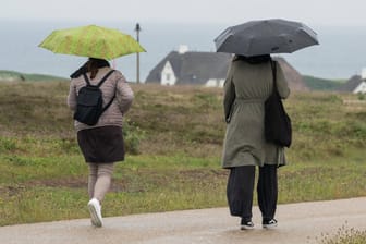 Touristen im Regen auf Sylt: Das Wetter im Juli ist laut Metoerologe Dalter bisher zu kühl – vor allem in der Nordhälfte wichen die Durchschnittstemperaturen um knapp 2 Grad vom Jahresmittel ab.