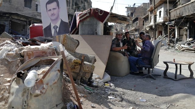 Syrische Soldaten haben einen Checkpoint der Armee im palästinensischen Flüchtlingslager von Jarmuk mit einem Bild des syrischen Präsidenten Baschar al-Assad versehen. Syrische Soldaten haben einen Checkpoint der Armee im palästinensischen Flüchtlingslager von Jarmuk mit einem Bild des syrischen Präsidenten Baschar al-Assad versehen.