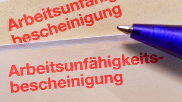Eine Arbeitsunfähigkeitsbescheinigung liegt auf einem Tisch.