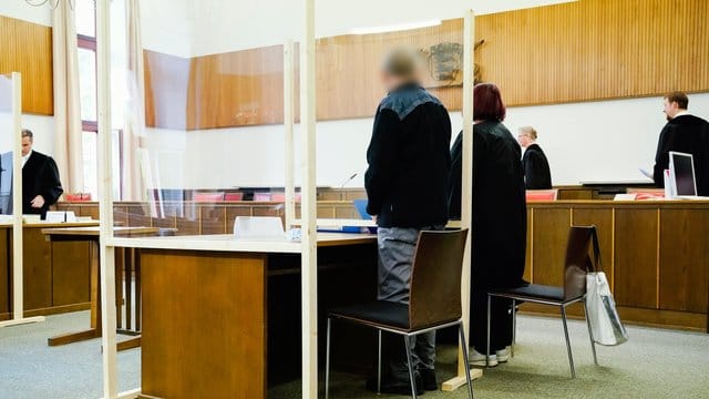 Der Angeklagte steht neben seiner Verteidigerin im Verhandlungssaal des Landgerichts. Der Angeklagte steht neben seiner Verteidigerin im Verhandlungssaal des Landgerichts.