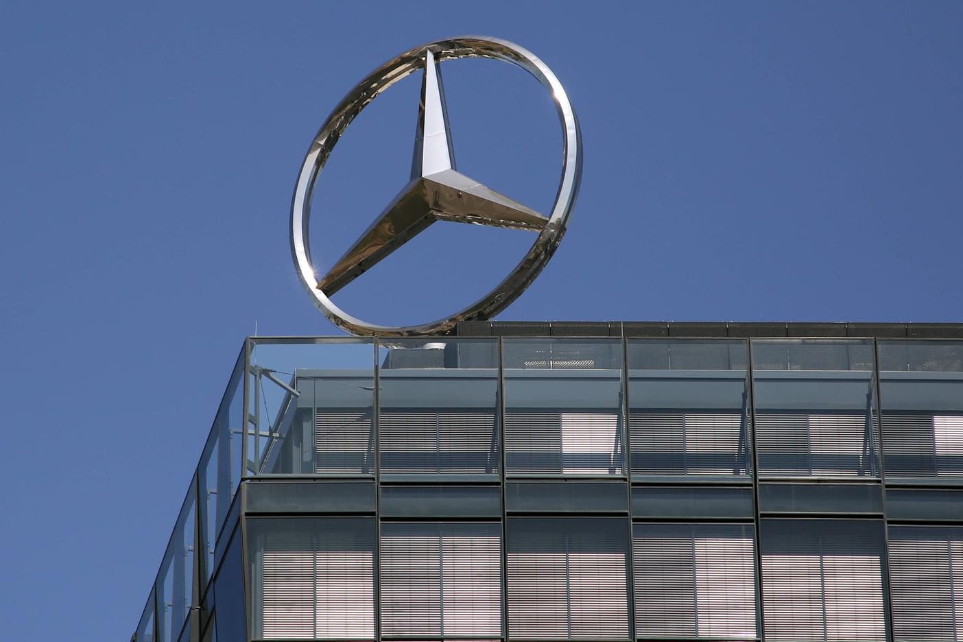 Mercedes-Stern auf einem Daimler-Gebäude (Symbolbild): Der Konzern muss kräftig sparen.
