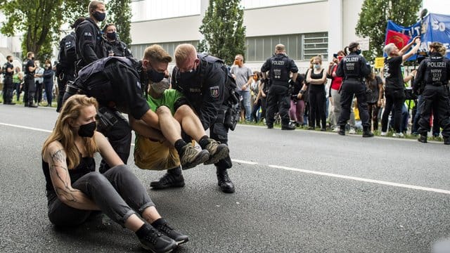 Polizisten tragen einen Aktivisten weg