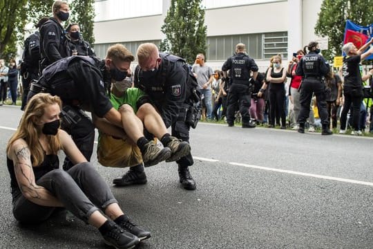 Polizisten tragen einen Aktivisten weg