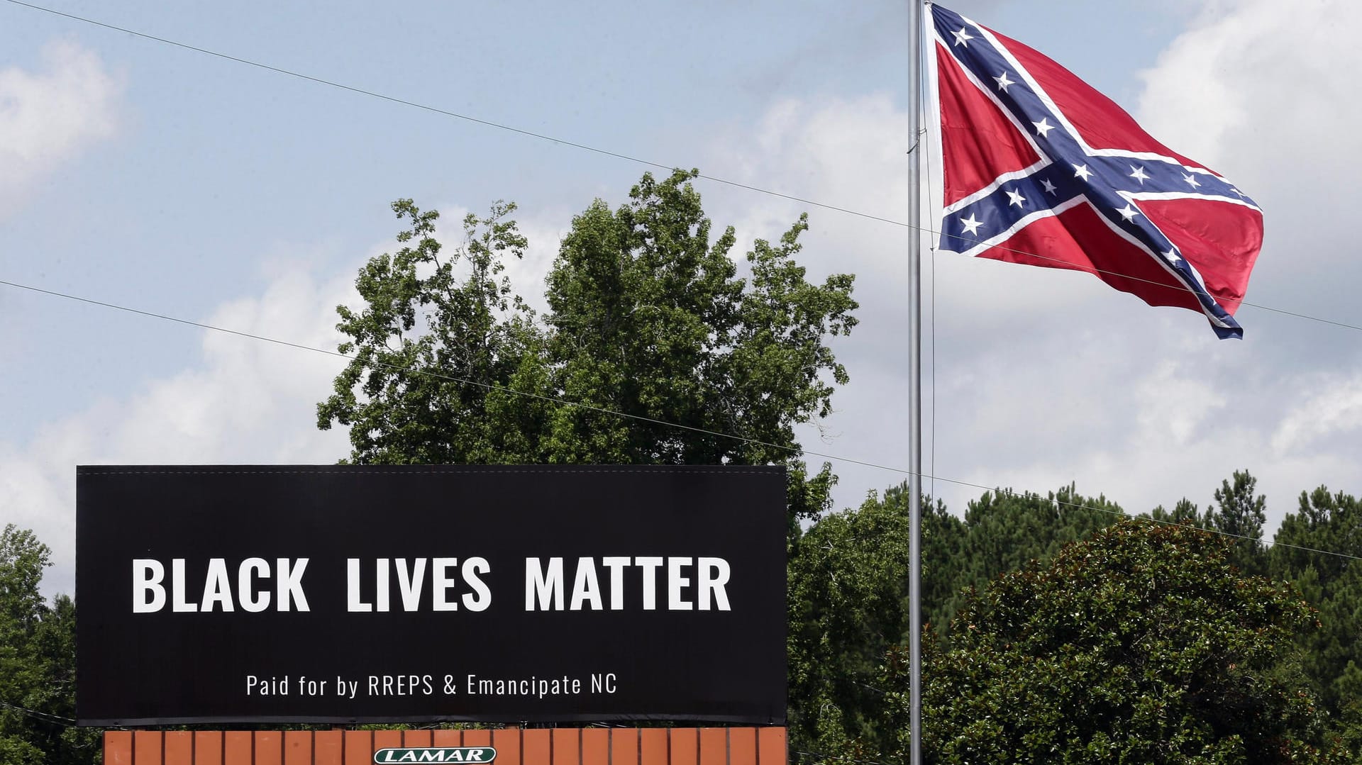 Black-Lives-Matter-Plakat neben Konföderiertenflagge: Viele Anhänger der Bewegung sehen die Fahne kritisch. Black-Lives-Matter-Plakat neben Konföderiertenflagge: Viele Anhänger der Bewegung sehen die Fahne kritisch.