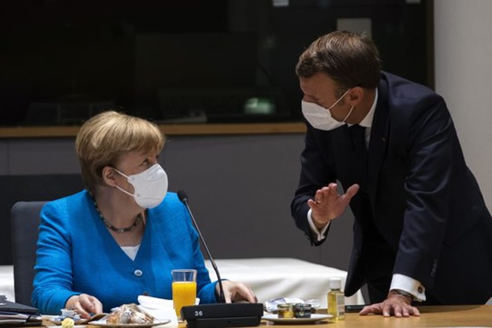 Bundeskanzlerin Angela Merkel spricht mit dem französischen Präsidenten Emmanuel Macron am zweiten Tag des EU-Gipfels.