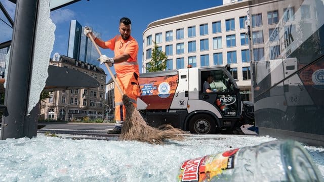 Mitarbeiter der Stadtreinigung beseitigen am Morgen vor der Alten Oper Scherben der zertrümmerten Scheiben einer Bushaltestelle. Mitarbeiter der Stadtreinigung beseitigen am Morgen vor der Alten Oper Scherben der zertrümmerten Scheiben einer Bushaltestelle.
