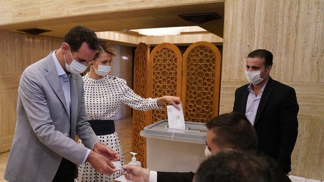 Baschar al-Assad, Präsident von Syrien, und seine Ehefrau Asma al-Assad, geben ihre Stimmzettel für die Parlamentswahlen in einem Wahllokal ab. Baschar al-Assad, Präsident von Syrien, und seine Ehefrau Asma al-Assad, geben ihre Stimmzettel für die Parlamentswahlen in einem Wahllokal ab.