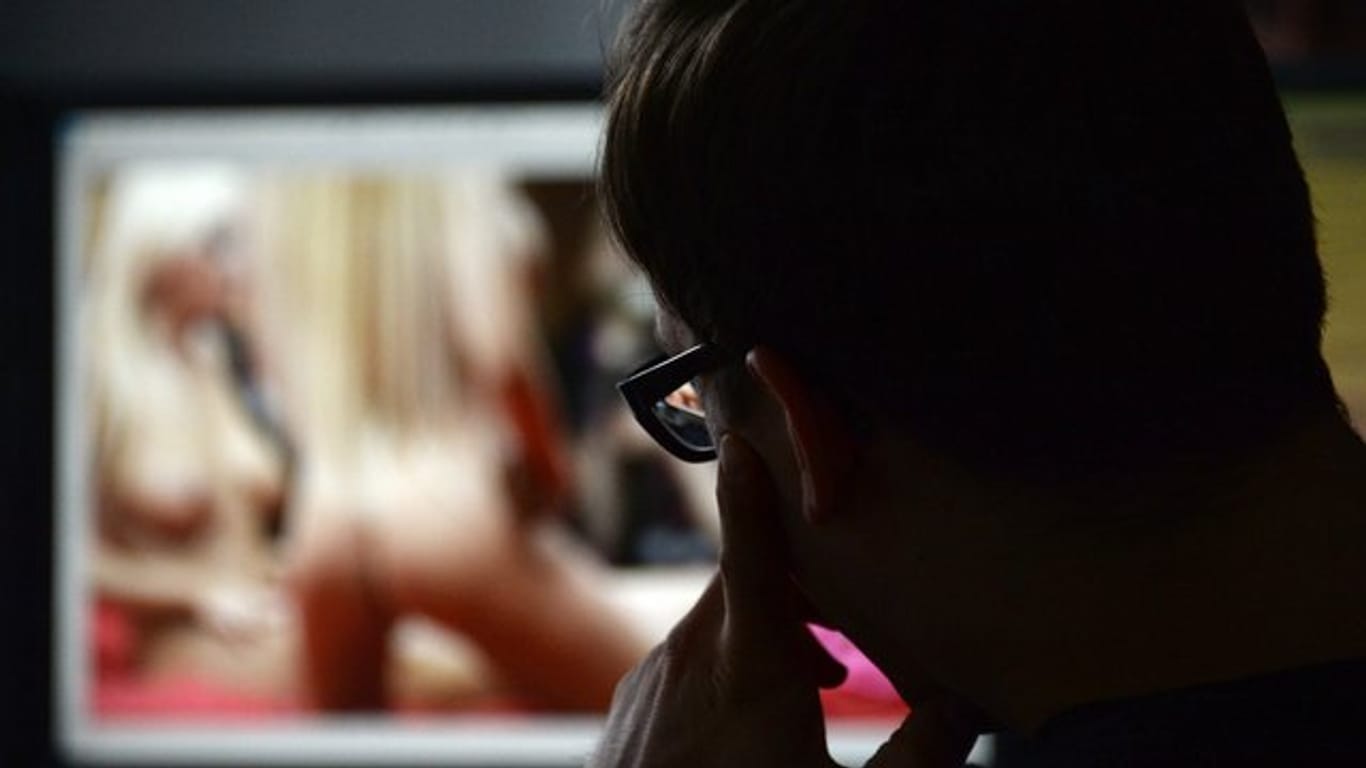 Ein Mann schaut sich auf einem Computer einen Porno an.
