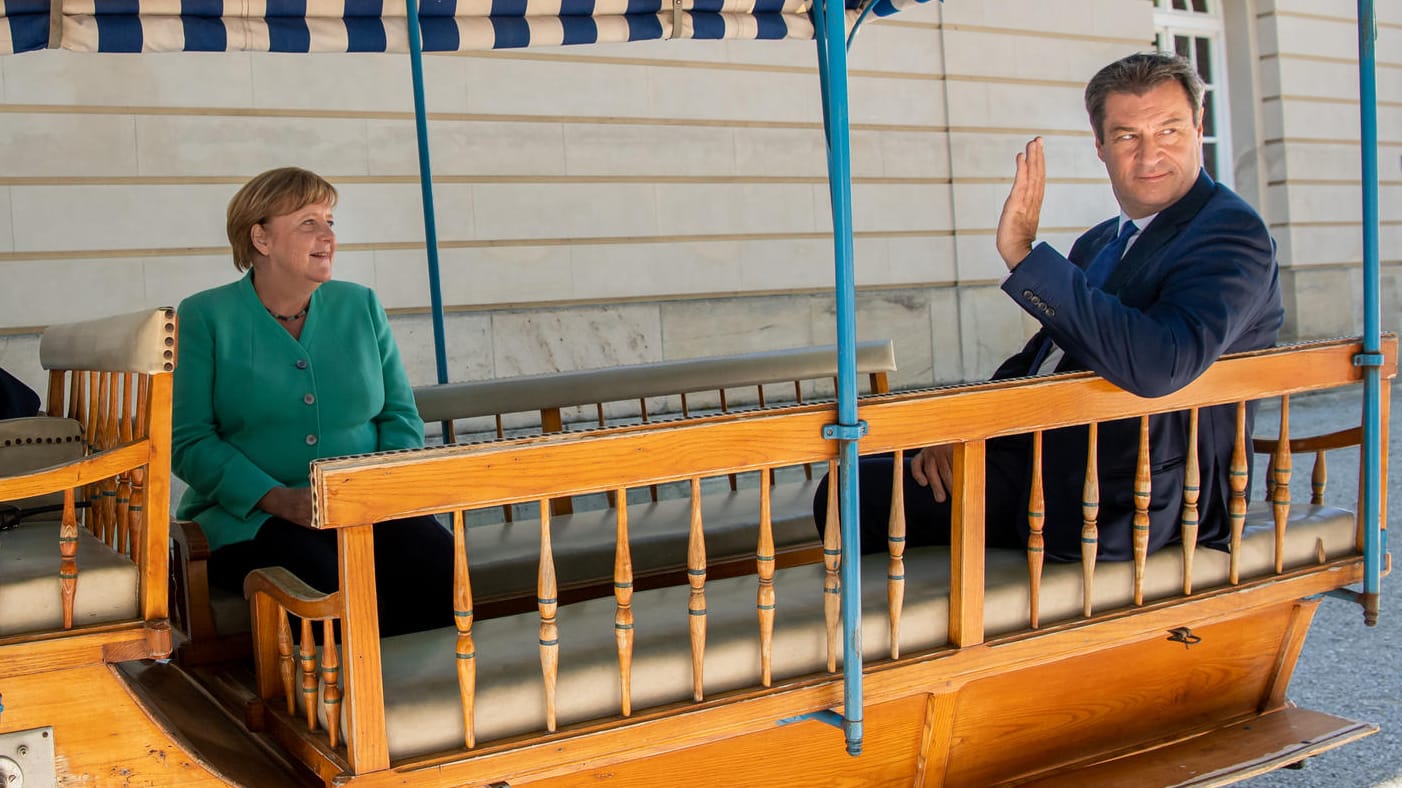 Bayern, Herrenchiemsee: Markus Söder und Bundeskanzlerin Angela Merkel fahren nach der Sitzung des bayerischen Kabinetts auf der Insel Herrenchiemsee in einer Kutsche zurück zum Anlegesteg.