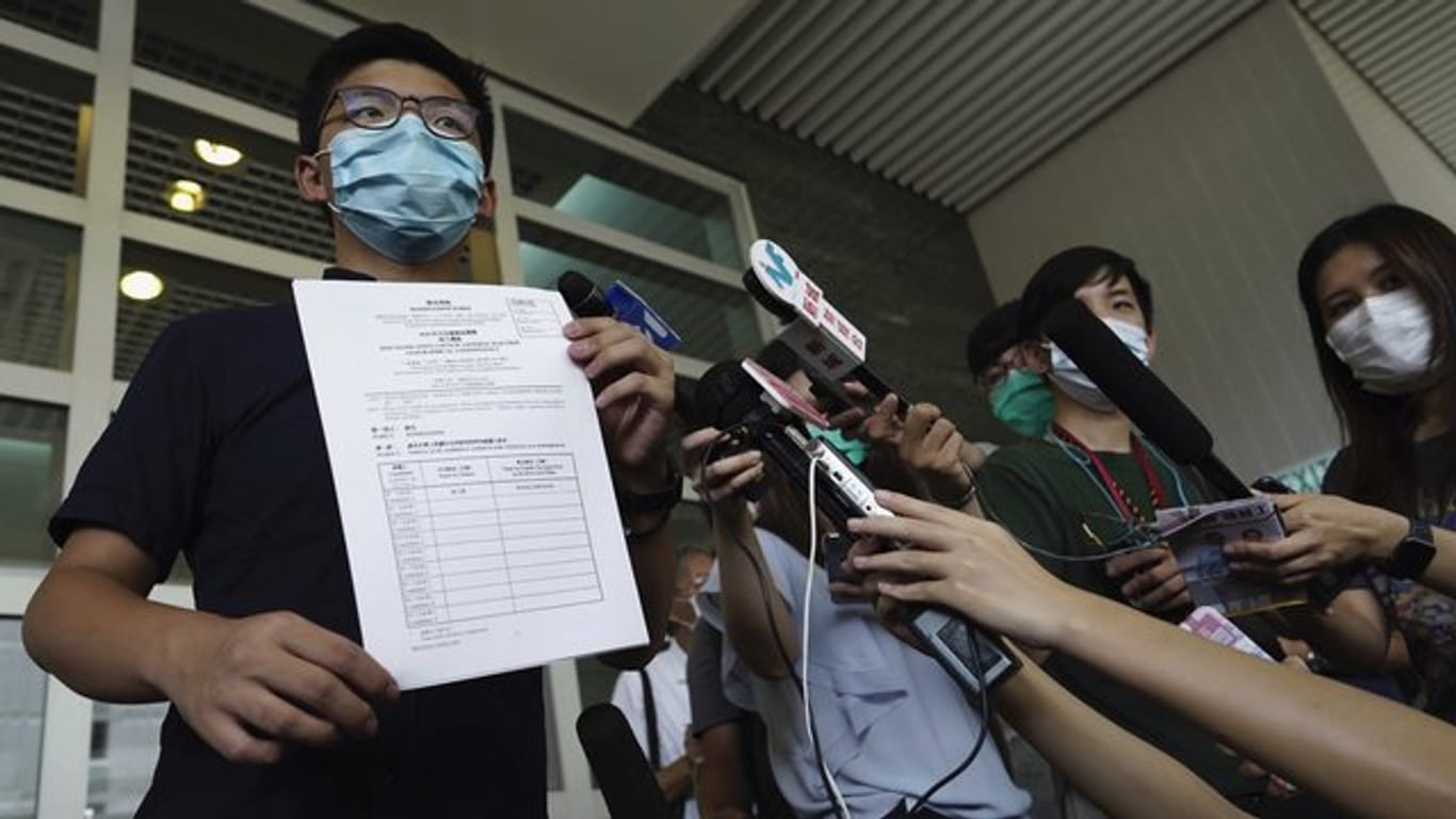Aktivist Joshua Wong zeigt Journalisten die Nominierungsunterlagen für die Parlamentswahl im September.