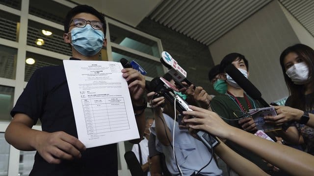 Aktivist Joshua Wong zeigt Journalisten die Nominierungsunterlagen für die Parlamentswahl im September. Aktivist Joshua Wong zeigt Journalisten die Nominierungsunterlagen für die Parlamentswahl im September.