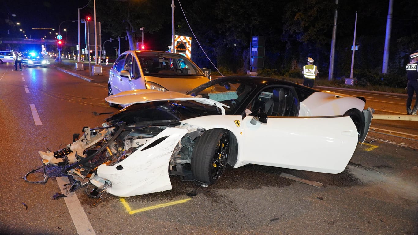 Ein defekter Sportwagen steht nach einem Unfall auf der Fahrbahn: Die Polizei sichert den Unfallort ab.