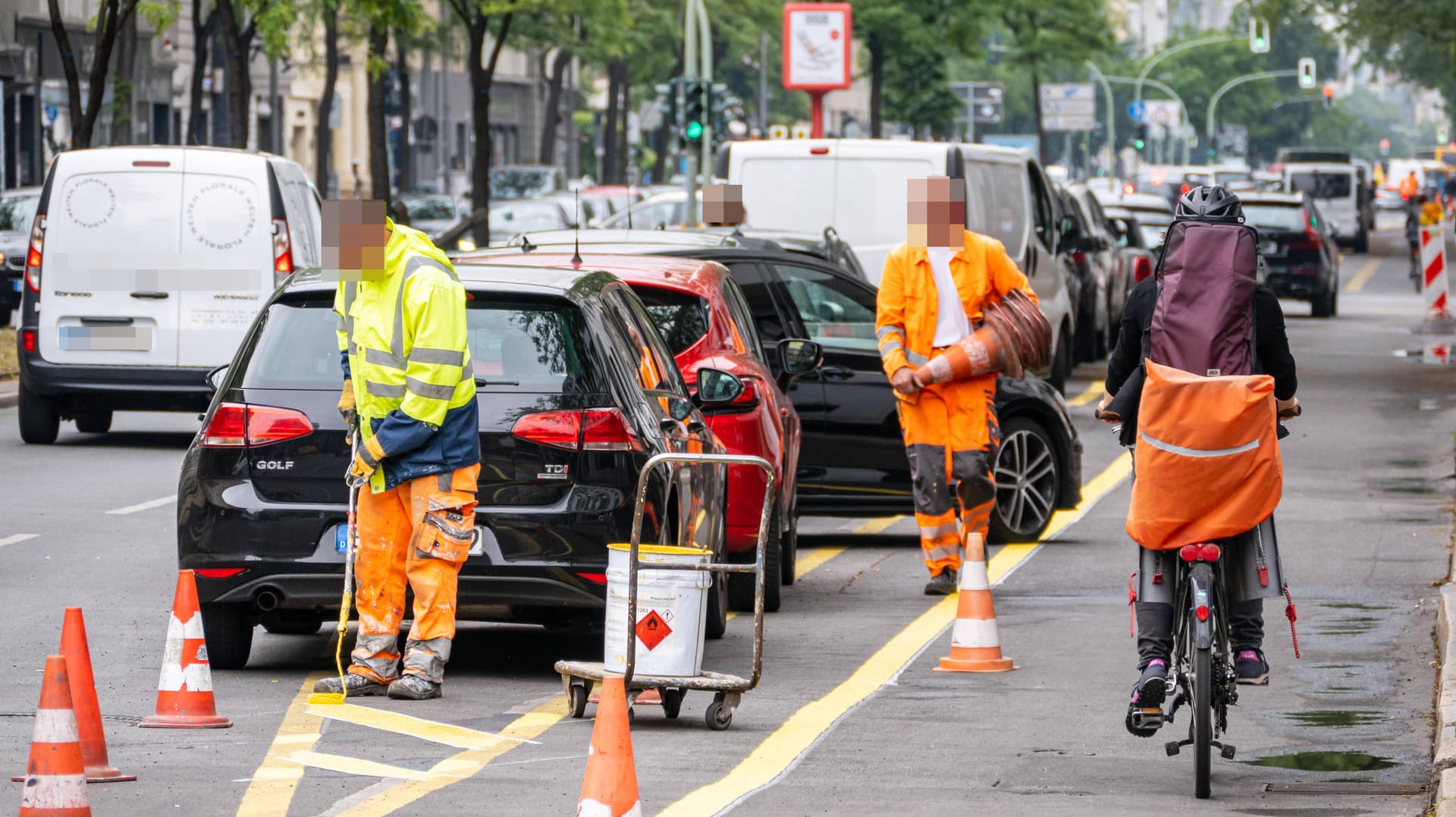 Arbeiter markieren Straße: Berlin fördert in der Corona-Krise mit sogenannten Pop-up-Radwegen den Fahrradverkehr.