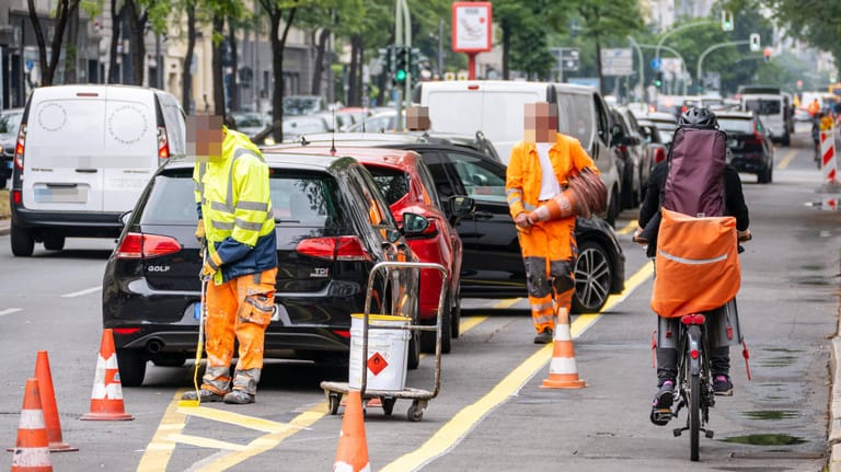 Arbeiter markieren Straße: Berlin fördert in der Corona-Krise mit sogenannten Pop-up-Radwegen den Fahrradverkehr.