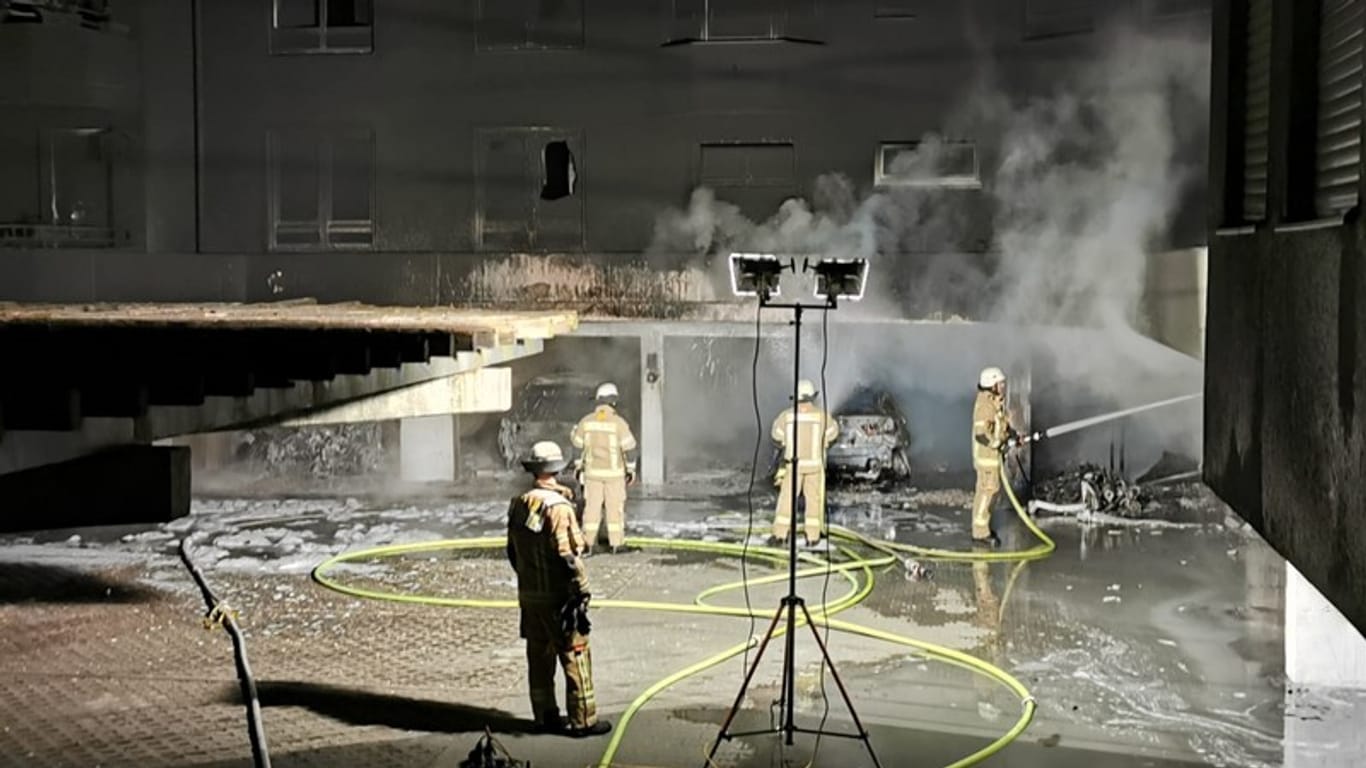 Feuerwehrmänner stehen vor ausgebrannten Garagen in Britz: Die Polizei hat den mutmaßlichen Brandstifter gefasst.