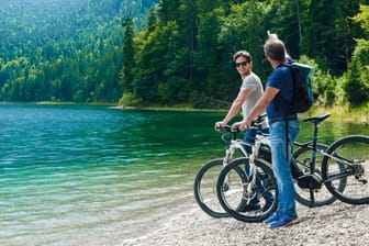 Zwei Männer mit Fahrrädern am Eibsee