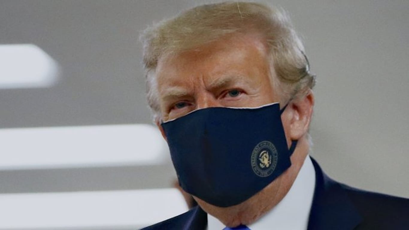 Donald Trump mit einem Stoff-Mundschutz, auf dem das Präsidenten-Siegel abgebildet ist. Donald Trump mit einem Stoff-Mundschutz, auf dem das Präsidenten-Siegel abgebildet ist.