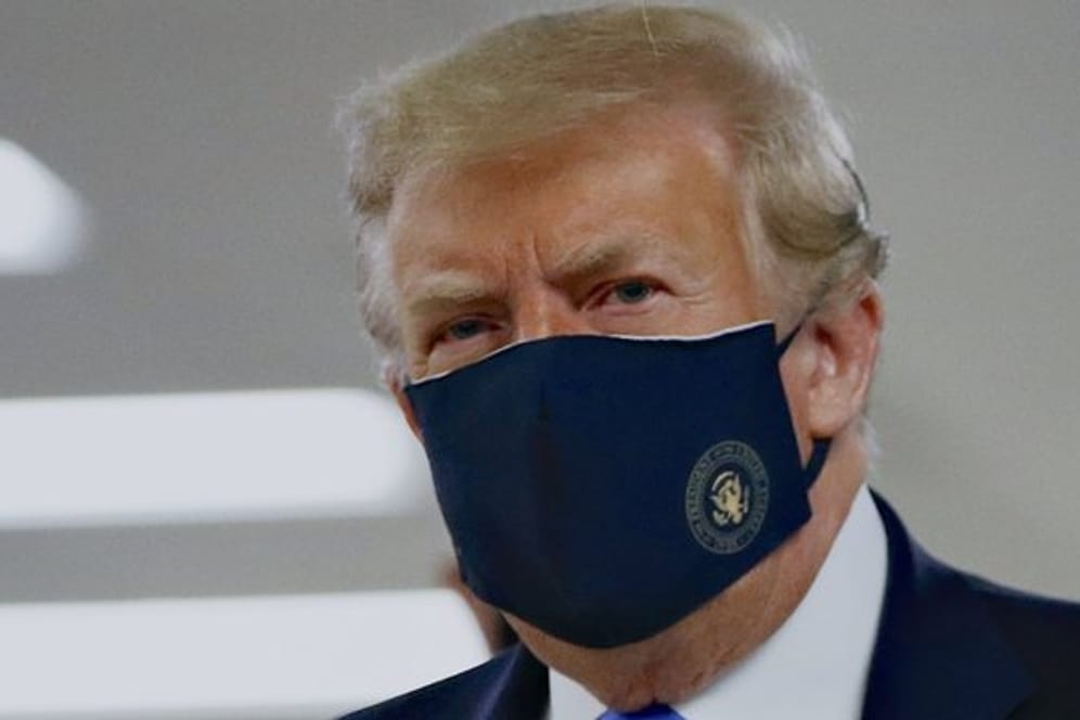 Donald Trump mit einem Stoff-Mundschutz, auf dem das Präsidenten-Siegel abgebildet ist.