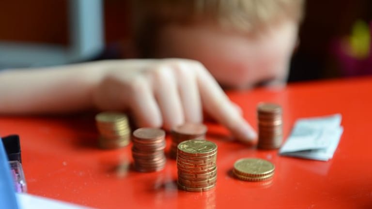 Ein Junge sortiert Kleingeld (Symbolbild): Viele Familien sind finanziell benachteiligt.