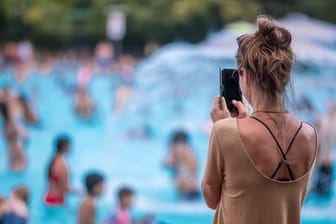 Eine junge Frau fotografiert mit ihrem Handy im Prinzenbad.