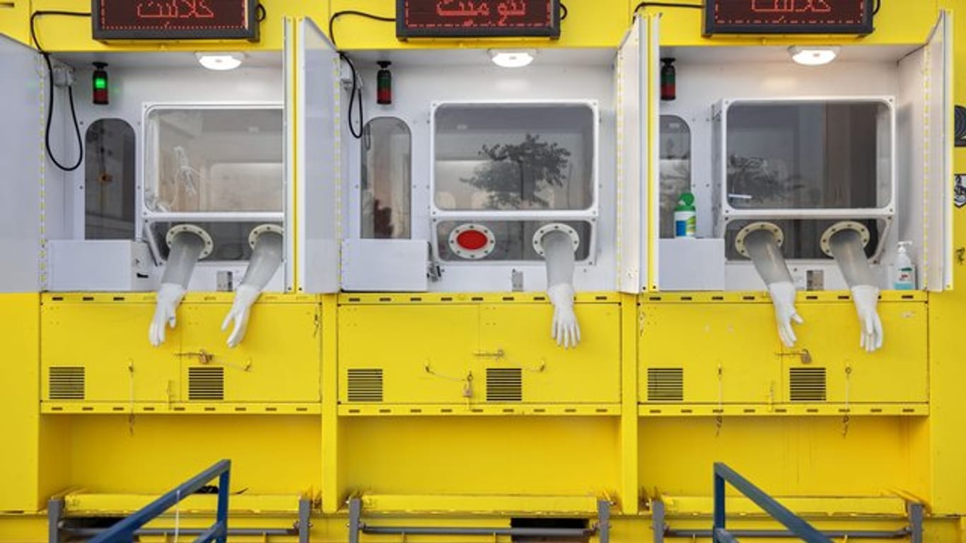 Handschuhe hängen aus Öffnungen einer mobilen Corona-Teststation in Ost-Jerusalem.