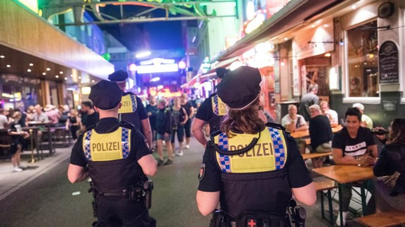 Polizisten gehen durch die Große Freiheit: In Hamburg haben am Wochenende zahlreiche Menschen trotz Corona-Pandemie das Nachtleben gefeiert.