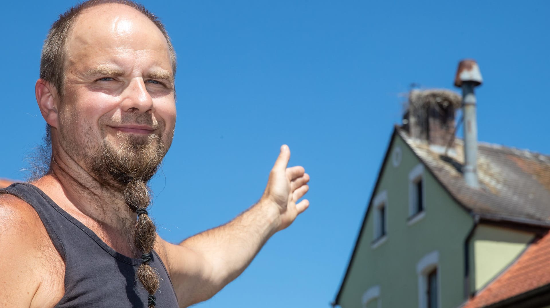 Bayern, Uehlfeld: Christian Zwanzger, Brauerei- und Gasthofbesitzer, zeigt auf ein Storchennest auf dem Schornstein der Brauerei des Gasthof Zwanzger.