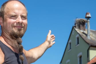 Bayern, Uehlfeld: Christian Zwanzger, Brauerei- und Gasthofbesitzer, zeigt auf ein Storchennest auf dem Schornstein der Brauerei des Gasthof Zwanzger.