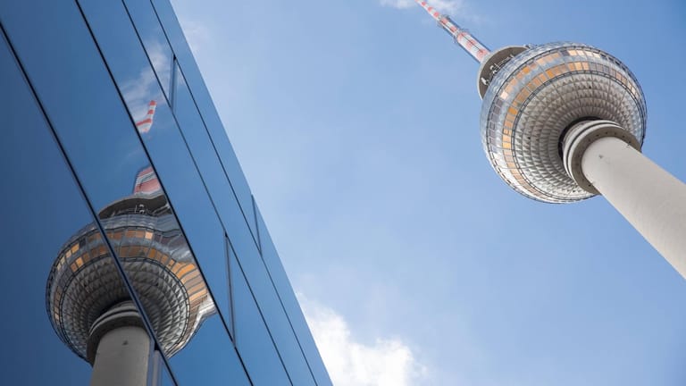 Der Fernsehturm spiegelt sich in einer Glasfassade: In Berlin sind mehrere Personen nach einem Lokalbesuch positiv getestet worden.