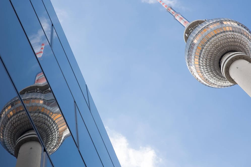 Der Fernsehturm spiegelt sich in einer Glasfassade: In Berlin sind mehrere Personen nach einem Lokalbesuch positiv getestet worden.