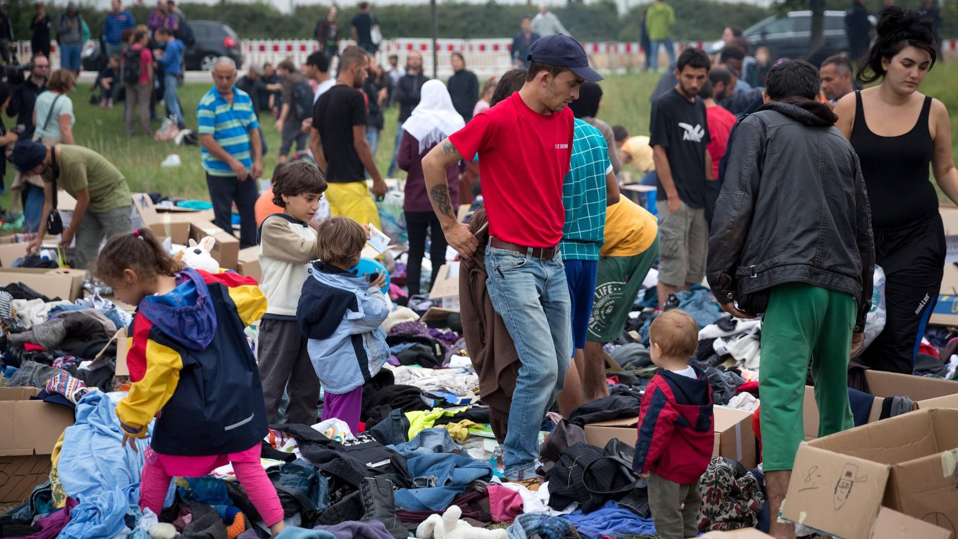 Geflüchtete suchen sich bei ihrer Ankunft Kleider aus Kleiderspenden.