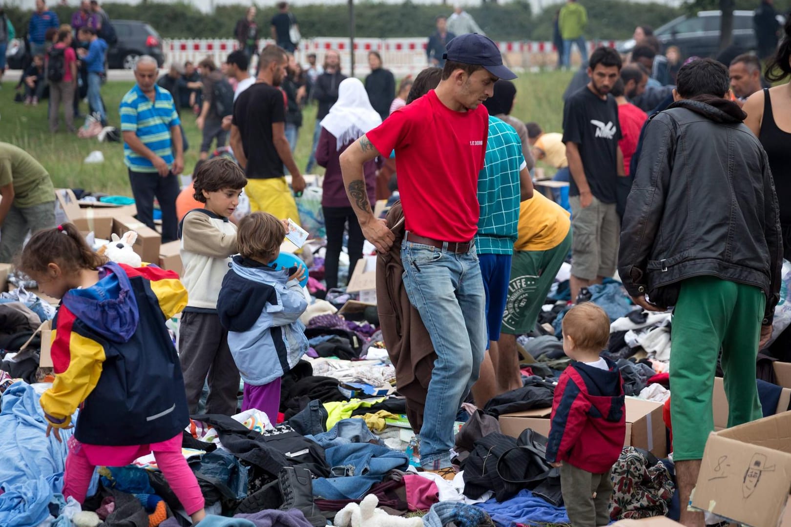 Geflüchtete suchen sich bei ihrer Ankunft Kleider aus Kleiderspenden.