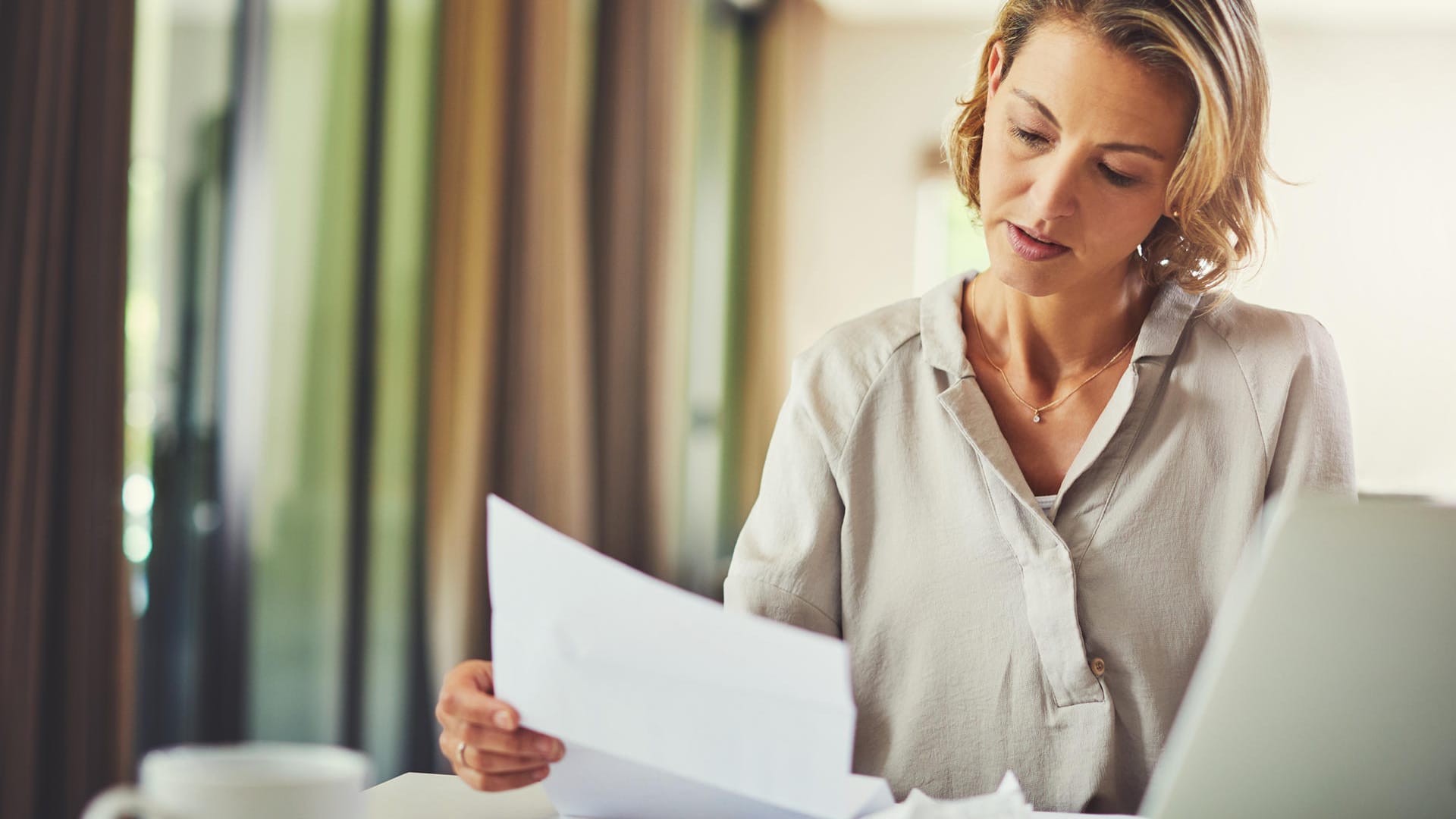 Eine Frau prüft ihre Finanzen (Symbolbild): In einem Portfolio stecken verschiedene Vermögenswerte.