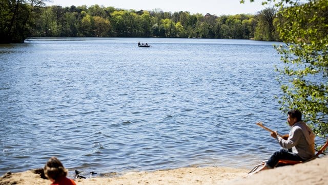 Zwei Personen genießen die Sonne am Ufer des Schlachtensees: Hier badet es sich besonders schön, hat ein Ranking ergeben.