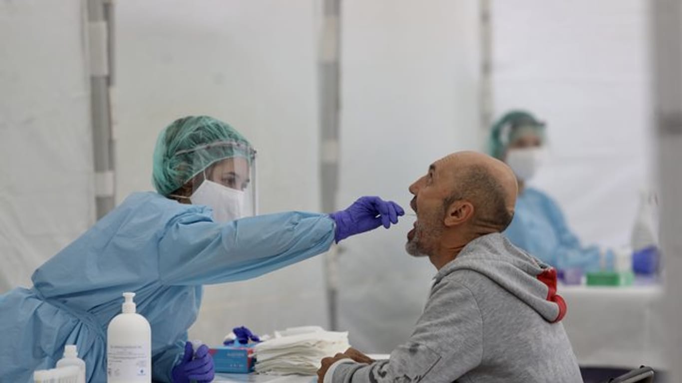 Eine Mitarbeiterin des spanischen Gesundheitswesens nimmt einen Abstrich.