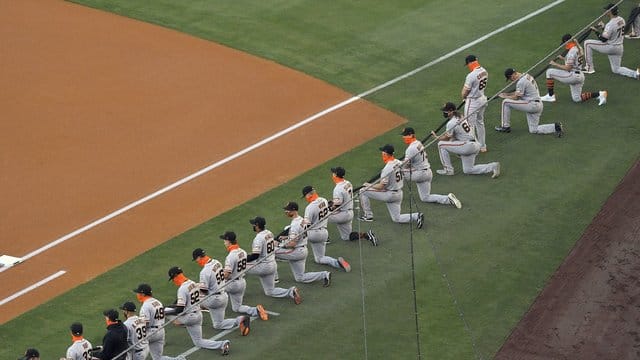 Die Spieler San Francisco Giants knien während einer Schweigeminute vor dem MLB-Eröffnungsspiel. Die Spieler San Francisco Giants knien während einer Schweigeminute vor dem MLB-Eröffnungsspiel.