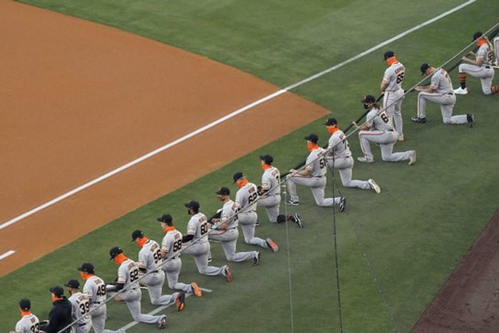 Die Spieler San Francisco Giants knien während einer Schweigeminute vor dem MLB-Eröffnungsspiel.