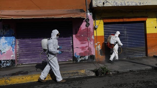 Coronavirus-Pandemie: In Mexiko-Stadt sprühen Arbeiter eine Desinfektionslösung auf die Straße. Coronavirus-Pandemie: In Mexiko-Stadt sprühen Arbeiter eine Desinfektionslösung auf die Straße.